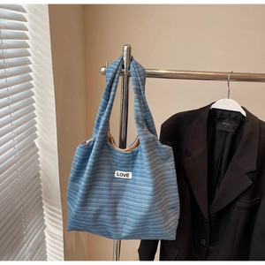 Detail of blue striped canvas tote bag with LOVE patch on silver metal hanger