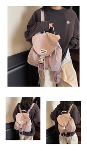 Detailed view of pink nylon drawstring backpack with buckle flap and white woven label
