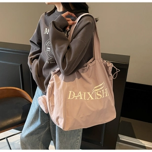 Close-up of pink oversized canvas tote with matching pouch shown on a model