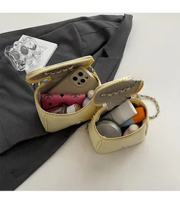 Détail de l'intérieur du sac beige compact contenant du maquillage et un portefeuille