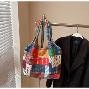 Detail of patchwork canvas tote bag featuring LOVE embroidery patch and vibrant patterns