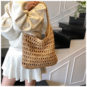Detail of hollow woven straw tote bag with shoulder strap and inner fabric lining