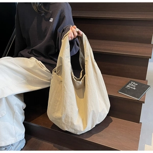 Dettaglio di una borsa tote in tessuto beige di grande capacità in nylon testurizzato