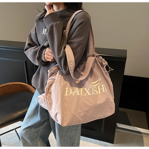 Detail of purple canvas tote bag with drawstring closure and white letter printing
