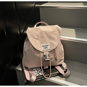 Detail of light purple nylon backpack featuring silver buckle and drawstring closure