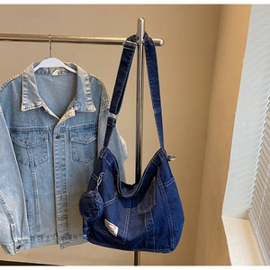 Detail of dark blue denim tote with adjustable strap and matching small round coin purse