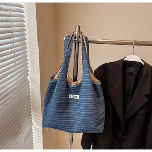 Detail of blue striped canvas tote bag with LOVE patch and spacious interior lining
