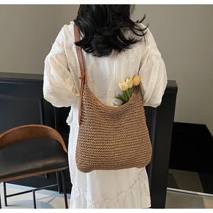 Detail of hand-woven straw shoulder bag with leather strap and natural texture