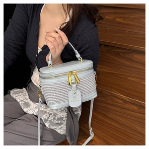 Detailed macro view of the light blue box bag featuring woven texture and gold hardware