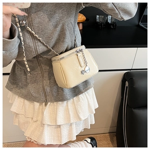 Detail of cream leather crossbody bag with adjustable gold metal ball chain strap