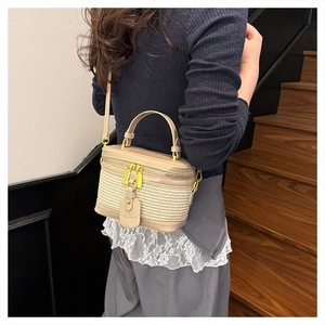 Detailed view of women straw weave box bag with leather trim and gold zipper
