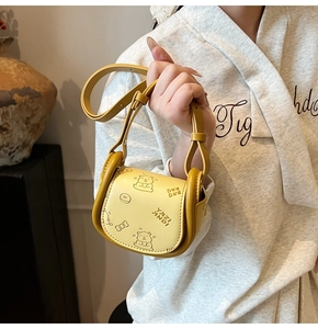 Detail of yellow saddle bag with cartoon bear prints and adjustable shoulder strap