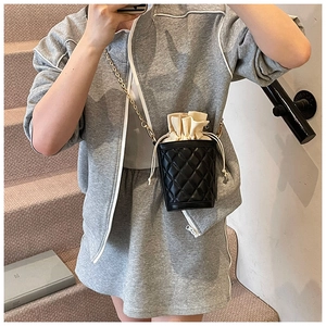 Quilted black bucket bag with beige drawstring lining and golden chain strap detail