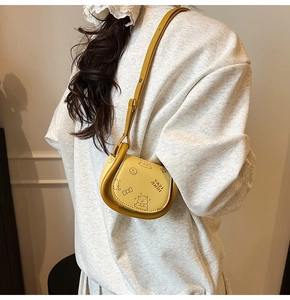 Detail of yellow saddle bag with bear prints worn with a casual grey hoodie