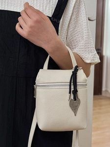 Creamy white litchi grain crossbody bag with silver heart charm and knot strap