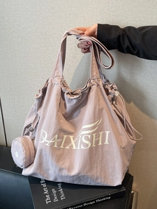 Dusty pink large drawstring tote bag with a small matching pouch and a brand logo