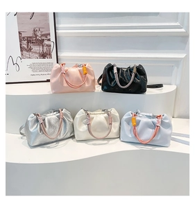 Five pleated cloud bags in assorted colors with colorful wrapped rope handles on a display