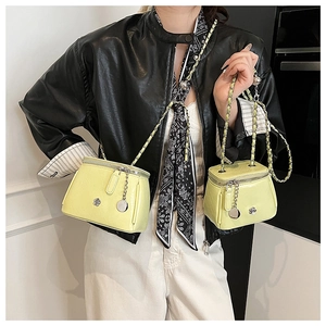 Détail de mini sacs boîte jaunes avec bandoulières tressées et fleurs en métal