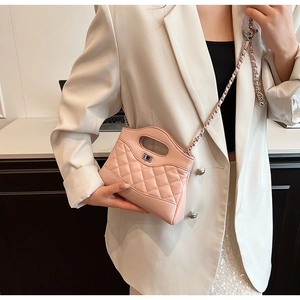 Close-up of pink quilted crossbody bag with silver chain strap and metal twist lock
