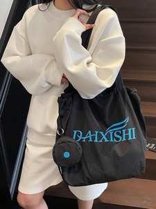 Black canvas tote bag with blue embroidery and small round pouch for daily commute
