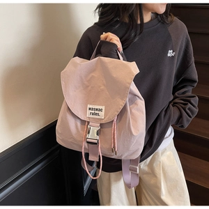 Detail of light purple drawstring bucket backpack with buckle closure and woven label