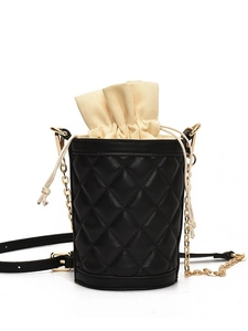 Quilted black bucket bag with beige drawstring liner and gold chain shoulder strap
