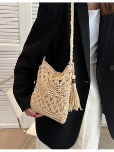 Beige handwoven straw crossbody bag with hollow floral pattern and wood bead tassels