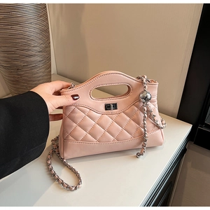 Close-up of pink quilted faux leather handbag with silver chain and metal ball detail
