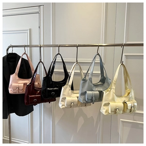 Detailed row of glossy patent leather hobo bags in six colors hanging on a rack