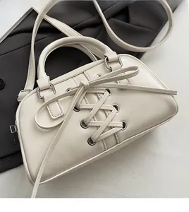 Dettaglio della borsa in ecopelle bianco crema con design stringato e occhielli in metallo
