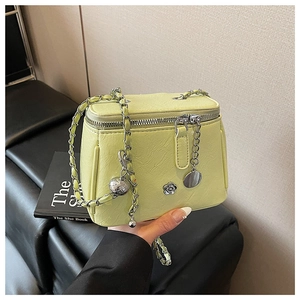 Détail du sac mallette avec bandoulière en chaîne et pendentif fleur en métal argenté