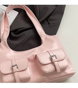 Detail of pink leather tote bag featuring two front pockets with metal buckle closures
