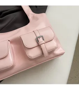 Close-up of pink leather tote bag with silver square buckle and exterior pocket