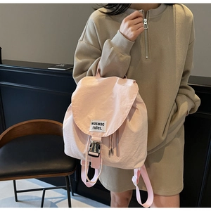 Detail of pink nylon bucket backpack with drawstring and silver buckle closure