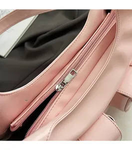Close-up of a smooth pink leather shoulder bag featuring a high-quality metal zipper detail