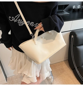 Top-down view of cream PU leather bucket bag with top handles and adjustable strap