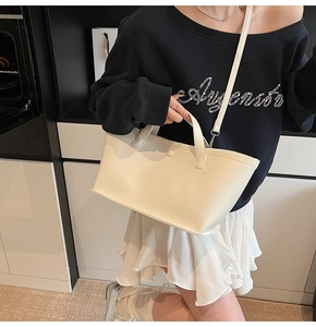 Modern creamy white leather bucket bag with top handles and detachable shoulder strap