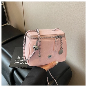 Gros plan du sac bandoulière en cuir rose avec chaîne argentée et rivets fleurs