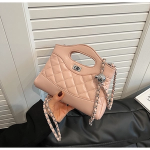 Detail of light pink quilted handbag with silver twist lock and woven chain strap