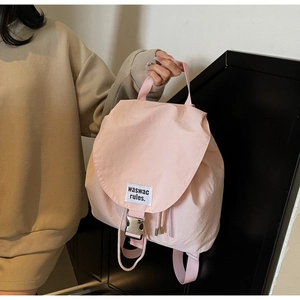 Detailed view of pink nylon bucket backpack with drawstring and metal buckle closure
