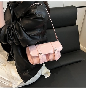 Detail view of pink retro crossbody bag featuring dual silver buckles and small front pockets