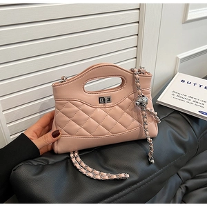 Detailed close-up of quilted light pink leather handbag with silver rotary metal lock