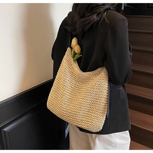 Detail of hand-woven straw shoulder bag with crochet texture and natural hobo design