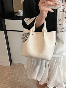 Beige grain leather bucket bag with knotted rope handle and silver bead charm