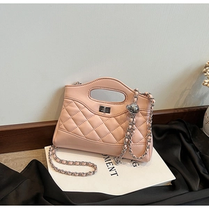 Close-up of pink quilted leather bucket bag with silver chain and metal ball charm