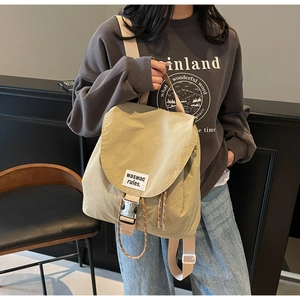 Detail of light khaki bucket backpack with drawstring and metal buckle closure