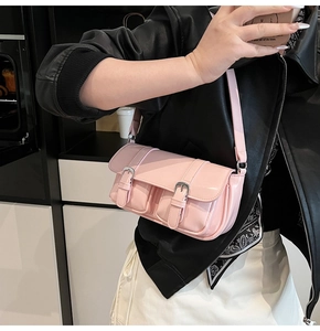 Side view of pink patent leather shoulder bag with double pockets and silver buckles