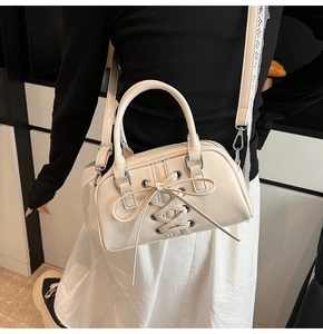 Dettaglio della borsa Boston con fiocco e tracolla rimovibile in bianco crema
