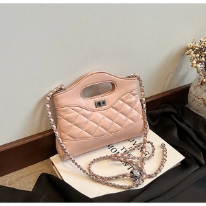 Macro shot of light pink quilted handbag with silver chain and metal turn-lock closure