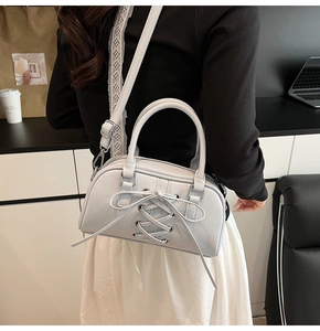 Dettaglio della borsa Boston in pelle verniciata celeste con design stringato stile corsetto